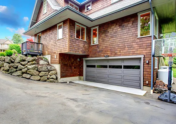 Suburban house with stone facade and large garage with brown roll-up door in Frisco, TX