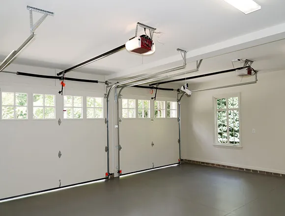 Interior of clean garage with white automatic garage door and opener motor installed on ceiling