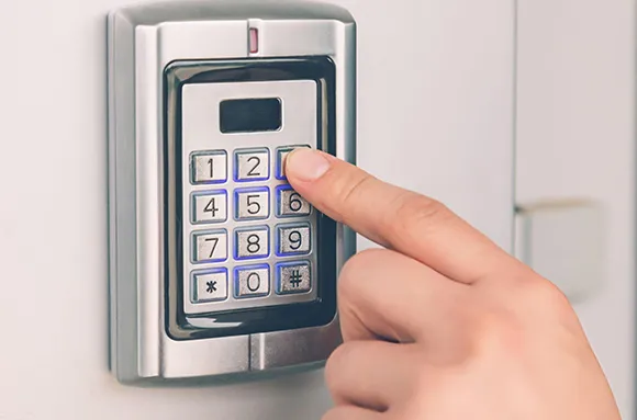 Hand pressing button on wireless garage keypad setup in Houston, TX for secure garage access.